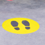 Pavement with a yellow circle with footprints in the middle